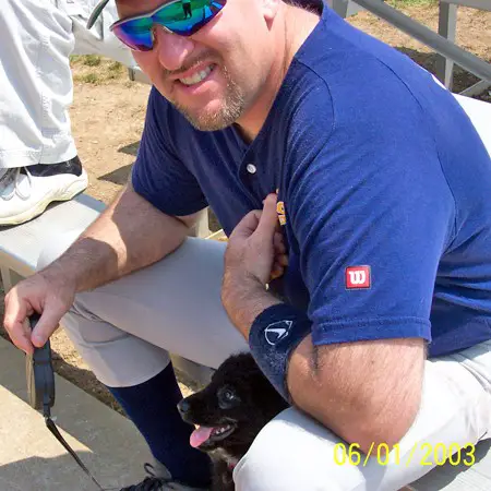 Destin is seeking shade between Jim's legs at the softball game.