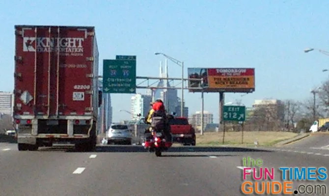 Motorcyclist riding with 2 small dogs on the bike in traffic on I65 in Nashville.