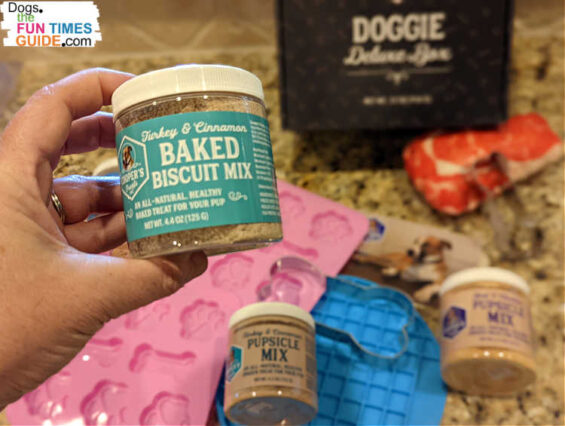 The Doggie Deluxe Kit from Cooper's Treats comes with 2 jars of biscuit mix, 2 jars of pupsicle mix, 2 bone- and paw-shaped silicone molds, 1 silicone lick mat, 3 bone-shaped cookie cutters, and 1 squeaky dog toy.