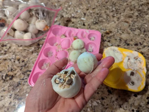 In my hand you can see 1 yogurt refill treat that was made using the WOOF silicone tray AND 1 yogurt refill ball that was made using the oven-safe & freezer-safe silicone molds I bought separately. photo by Lynnette at TheFunTimesGuide.com In my hand you can see 1 yogurt refill treat that was made using the WOOF silicone tray AND 1 yogurt refill ball that was made using the oven-safe & freezer-safe silicone molds I bought separately.